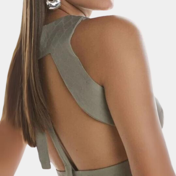 Vrouw in stijlvolle, grijze, mouwloze jurk met open rug en lange, rechte haren. Elegante mode, trendy avondkleding, minimalistisch design.