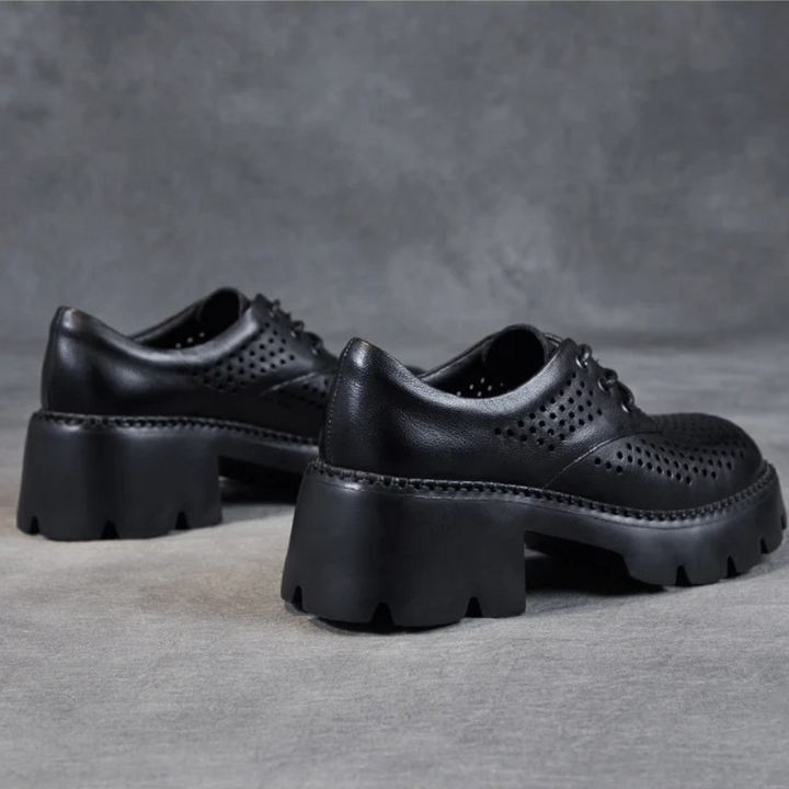 Zwarte leren damesschoenen met dikke plateauzolen en perforaties, stijlvolle veterschoenen voor dagelijks gebruik. Trendy en comfortabel schoeisel.