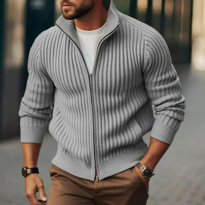 Grijze geribbelde heren vest met rits, gedragen over een wit T-shirt. Stijlvolle casual herenkleding, perfect voor herfstmode.