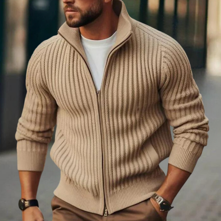 Man in khaki ribgebreide trui met rits, witte T-shirt eronder, wandelend op straat. Modieuze herenkleding, casual stijl, herfstmode.
