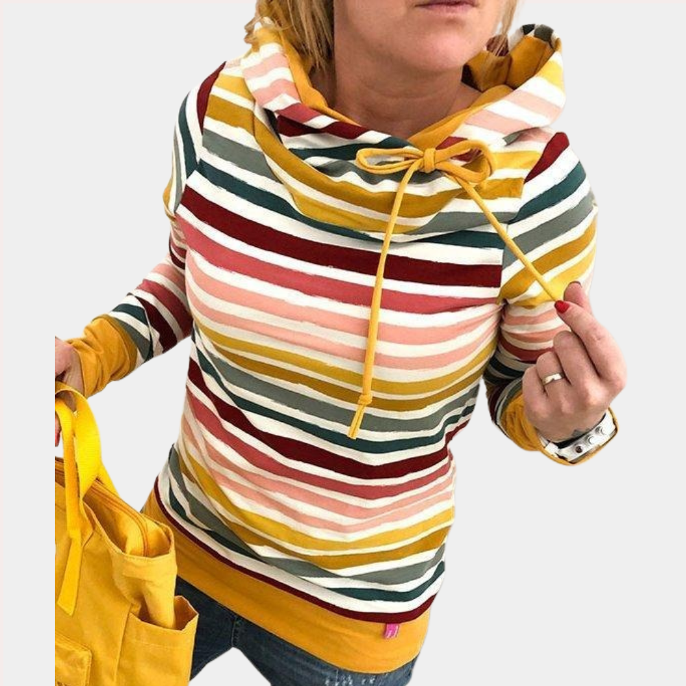 Vrouw in kleurrijke gestreepte hoodie met capuchon en gele accenten, houdt gele tas vast. Modieuze dameskleding, casual stijl, herfstmode.