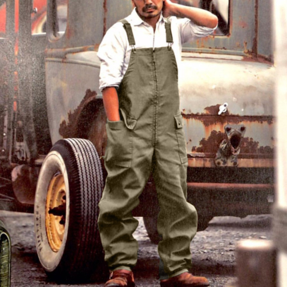 Man in groene overall voor vintage vrachtwagen, casual kleding, industriële stijl, werkoutfit, retro mode, buitenomgeving.