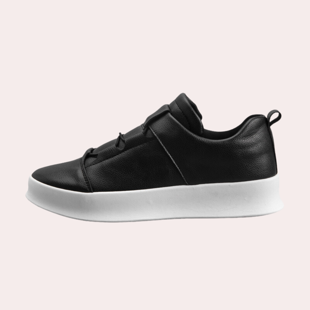 Zwarte leren sneaker met witte zool, minimalistisch design, zijaanzicht. Perfect voor casual en sportieve outfits. Unisex modeaccessoire.