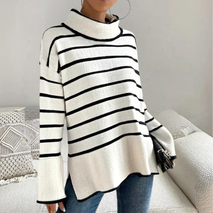 Vrouw draagt een wit-zwart gestreepte trui met col, gecombineerd met blauwe jeans. Modieuze dameskleding, casual stijl, herfst-winter outfit.