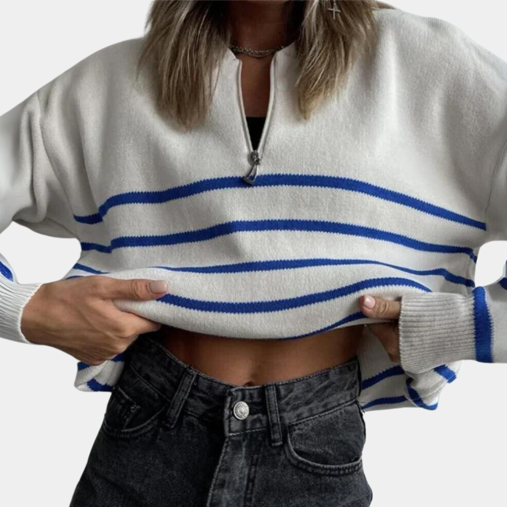 Witte trui met blauwe strepen, halve rits en lange mouwen, gedragen door persoon met zwarte jeans. Trendy damesmode, casual stijl.
