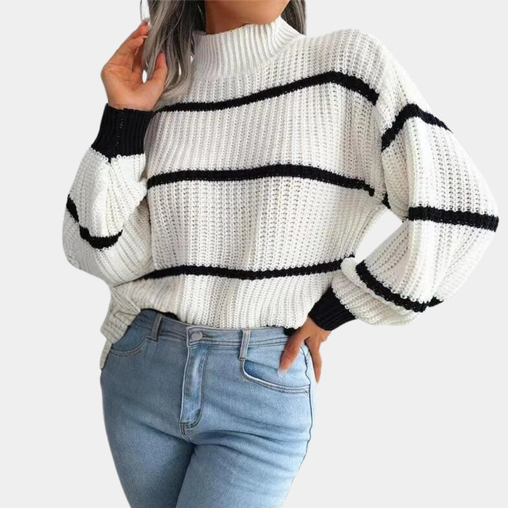 Witte gebreide trui met zwarte strepen, hoge hals en lange mouwen, gedragen met lichtblauwe jeans. Modieuze dameskleding, herfst/winter stijl.