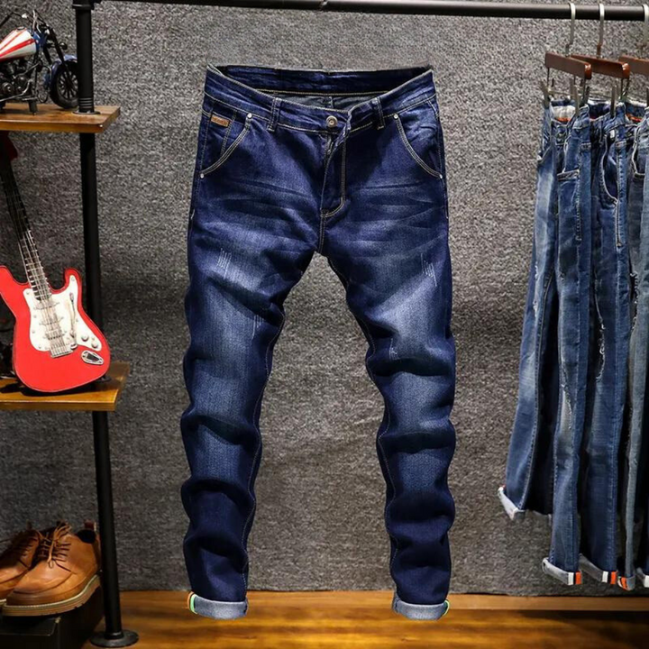 Donkerblauwe spijkerbroek voor heren, casual stijl, opgehangen in een kledingwinkel. Ideaal voor dagelijks gebruik, modieuze denim jeans.