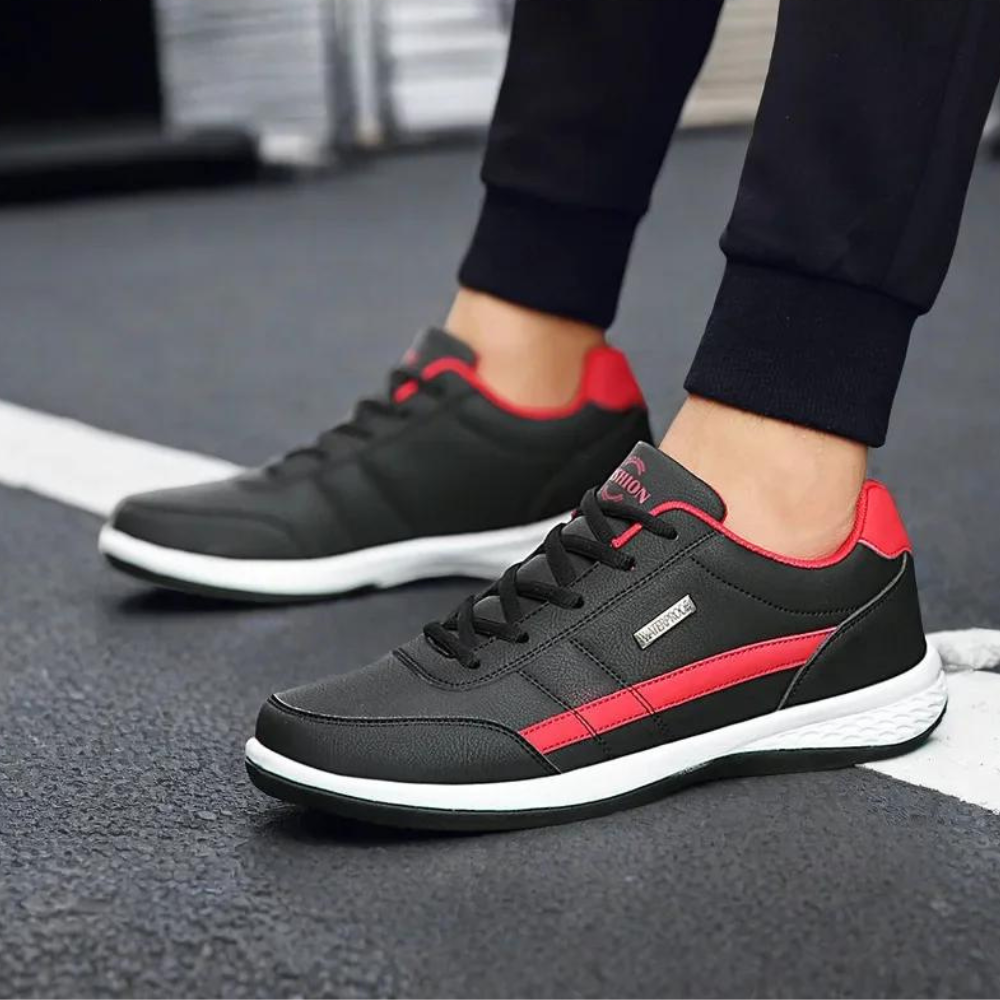 Zwarte en rode sneakers voor heren op asfaltweg, sportief design, comfortabele pasvorm, ideaal voor dagelijks gebruik en casual outfits.
