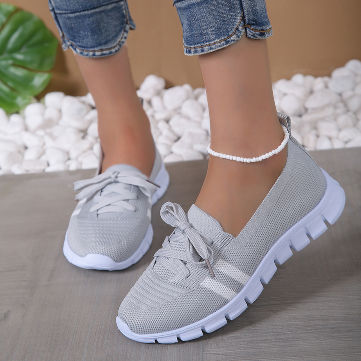 Grijze dames sneakers met witte zool, comfortabele pasvorm, casual stijl, perfect voor dagelijks gebruik. Ideaal voor mode en comfort.