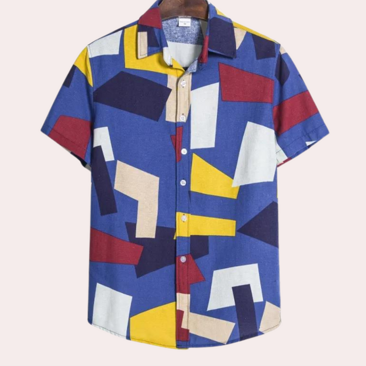Blauw overhemd met korte mouwen, abstracte geometrische patronen in rood, geel en wit. Moderne herenmode, casual zomerstijl.