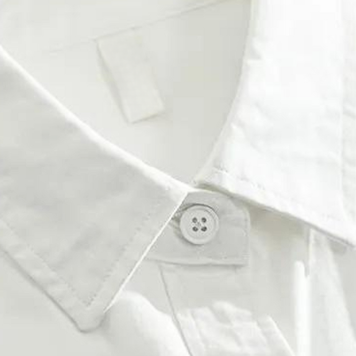 Witte katoenen overhemdkraag met knoopdetail, close-up. Hoogwaardige herenmode, formele kleding, stijlvolle zakelijke outfit.
