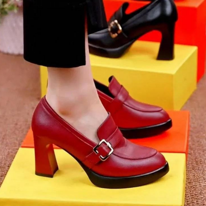 Rode leren damesschoenen met blokhak en gesp, stijlvolle pumps voor dagelijks gebruik, modieuze schoenen op kleurrijke achtergrond.