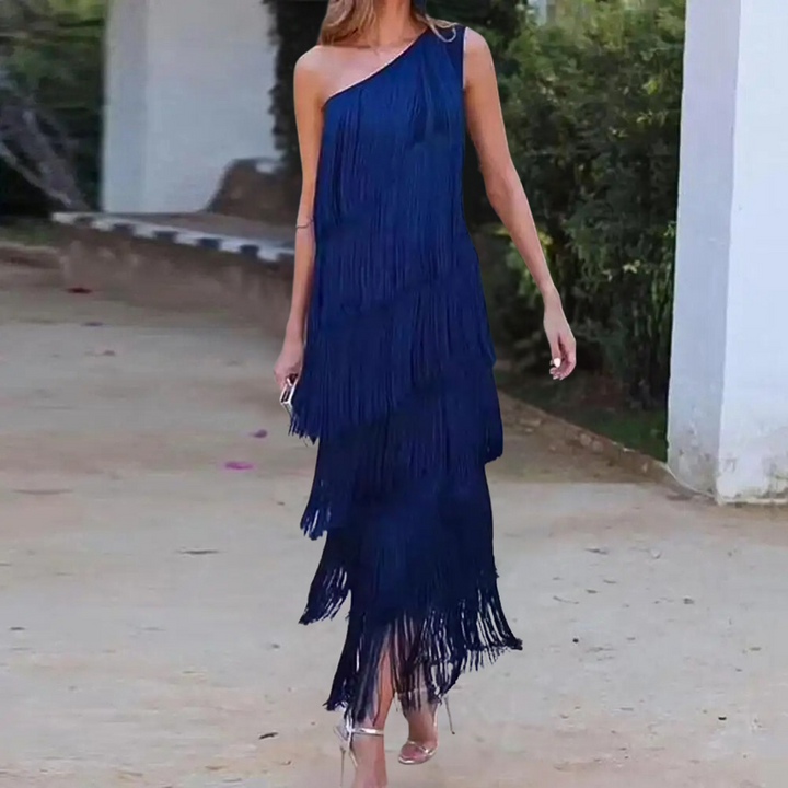 Vrouw in elegante blauwe asymmetrische jurk met franjes, buiten gefotografeerd. Perfect voor avondkleding, modetrend, stijlvolle damesmode.