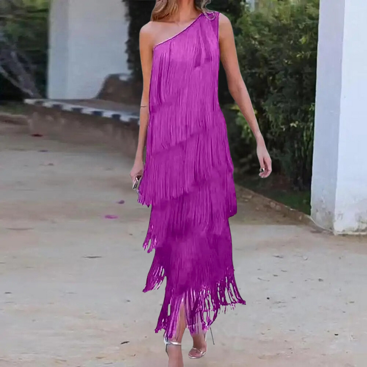 Vrouw in paarse asymmetrische franjesjurk, buiten gefotografeerd. Trendy avondkleding, perfect voor feestelijke gelegenheden.