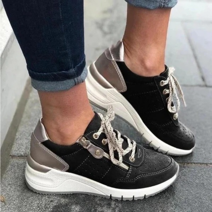Zwarte dames sneakers met witte zool en zilveren details, casual en sportief, perfect voor dagelijks gebruik. Comfortabele en trendy schoenen.
