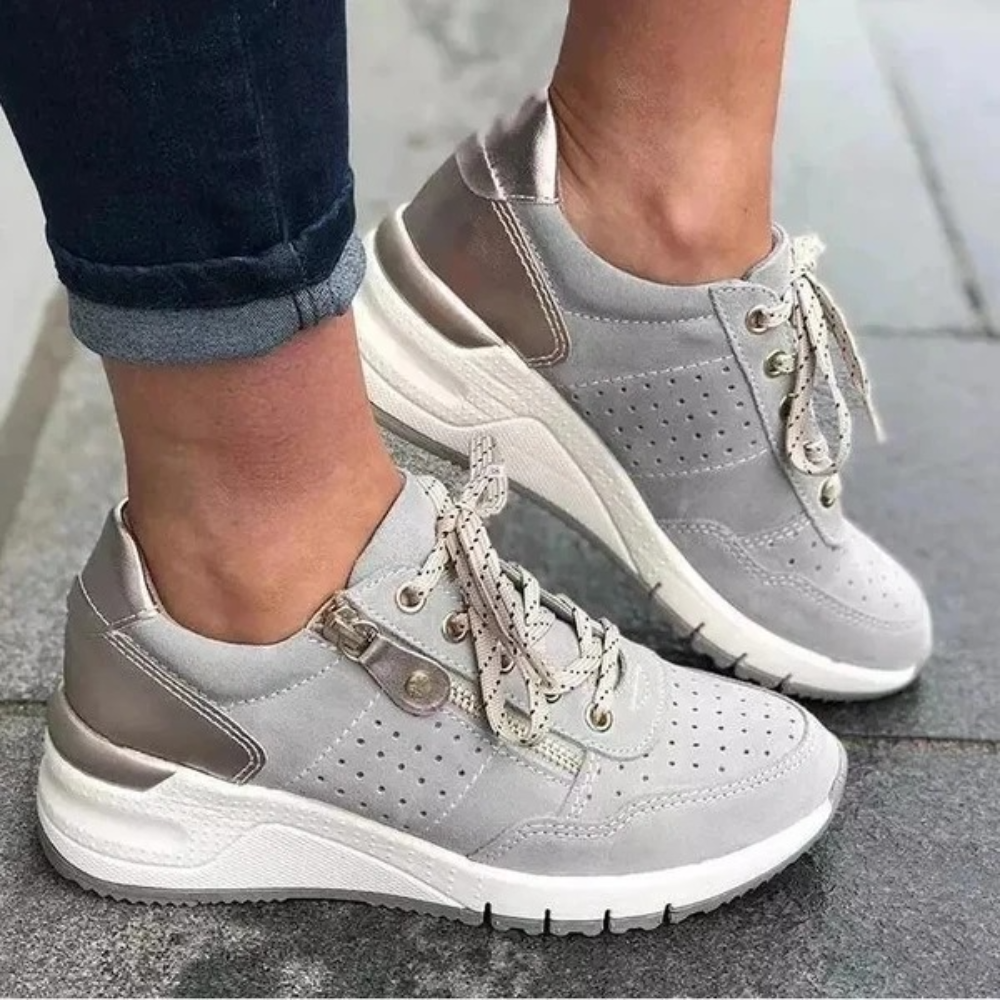 Grijze dames sneakers met dikke witte zool, perforaties en veters. Comfortabele casual schoenen voor dagelijks gebruik. Trendy en stijlvol ontwerp.