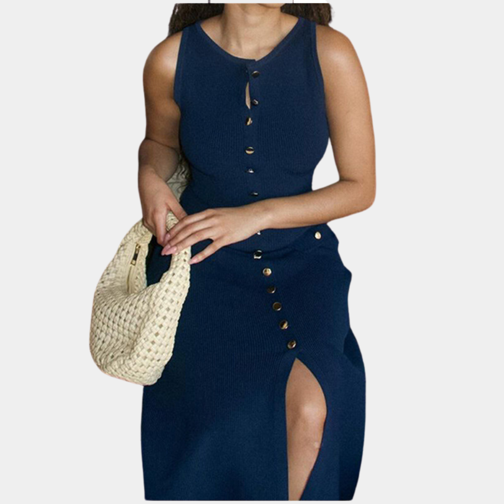Vrouw in marineblauwe jurk met knoopsluiting en split, houdt een beige gevlochten tas vast. Elegante damesmode, zomerjurk, casual chique stijl.