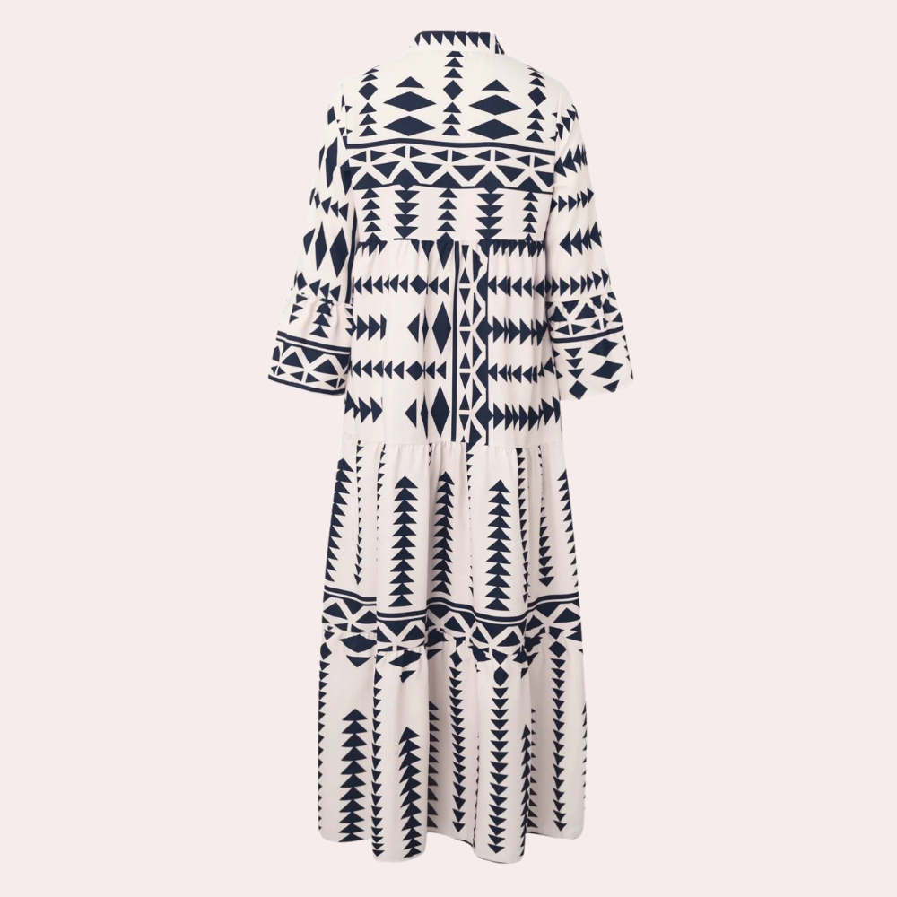 Achterkant van een lange, witte jurk met geometrische zwarte patronen, driekwart mouwen en een losse pasvorm. Perfect voor zomer- en boho-stijl.