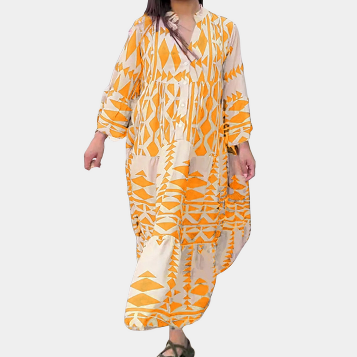 Lange damesjurk met oranje geometrisch patroon, losse pasvorm, lange mouwen, V-hals. Perfect voor zomerse dagen en casual gelegenheden.