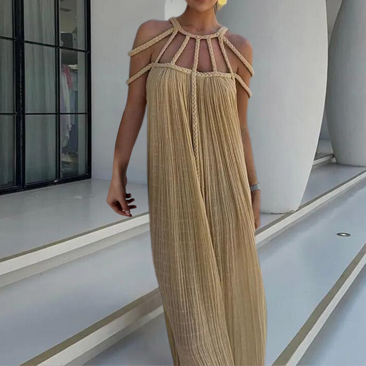 Beige maxi-jurk met gevlochten bandjes, elegante plissé stof, perfect voor zomerse evenementen. Trendy damesmode, stijlvolle avondjurk.