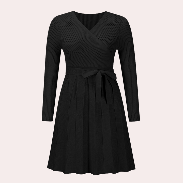 Zwarte gebreide jurk met lange mouwen en V-hals, voorzien van een strikceintuur en geplooide rok. Perfect voor elegante en stijlvolle gelegenheden.
