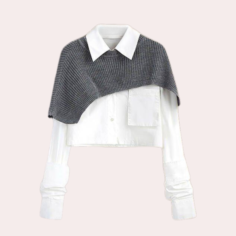 Grijze gebreide schoudercape over witte blouse, modieuze dameskleding, stijlvolle herfstoutfit, trendy lagen, casual chique look.