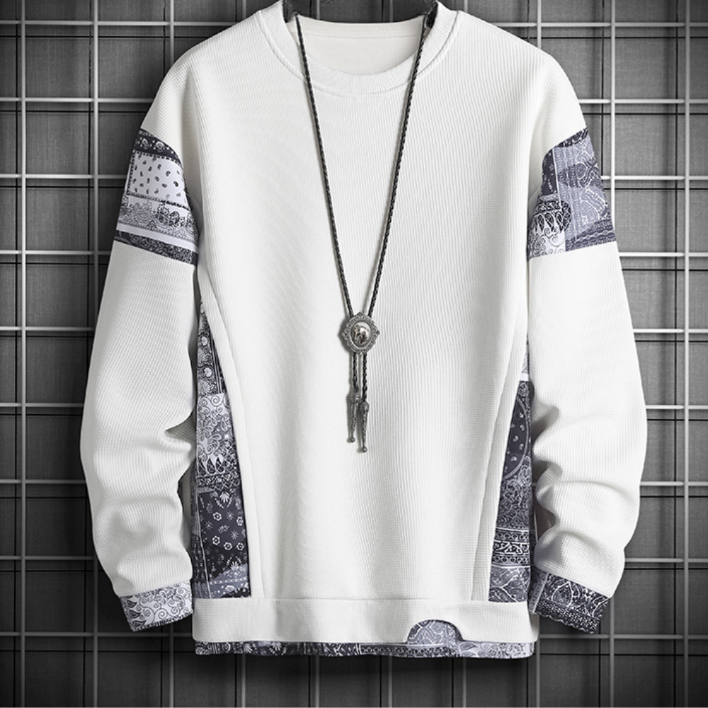 Witte trui met zwart-witte paisley-patronen en lange ketting, moderne herenkleding, stijlvolle streetwear, casual mode, trendy design.
