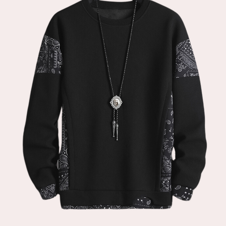 Zwarte trui met paisley-patronen en lange mouwen, versierd met een opvallende hangerketting. Stijlvolle herenkleding, casual en trendy.