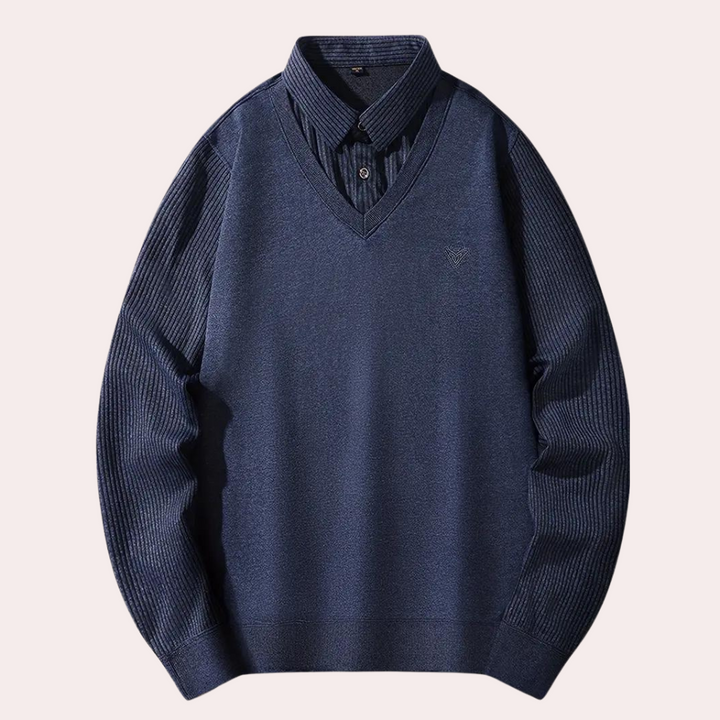 Donkerblauwe heren trui met V-hals en geribbelde mouwen, over een donkerblauw overhemd. Stijlvolle herenkleding, casual en elegant.
