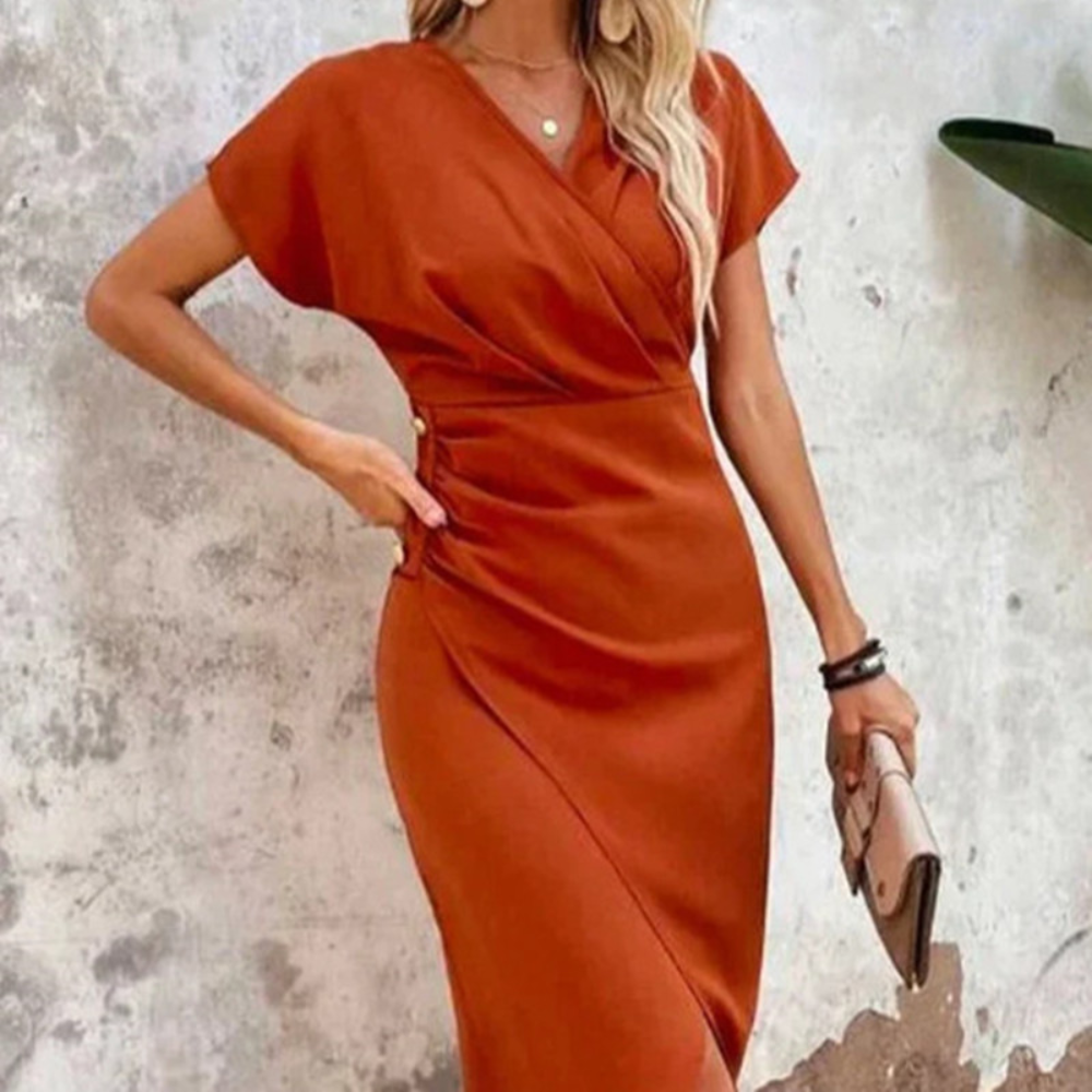 Oranje-rode wikkeljurk met korte mouwen, elegante pasvorm, gedragen door vrouw. Perfect voor zomer, casual en formele gelegenheden.