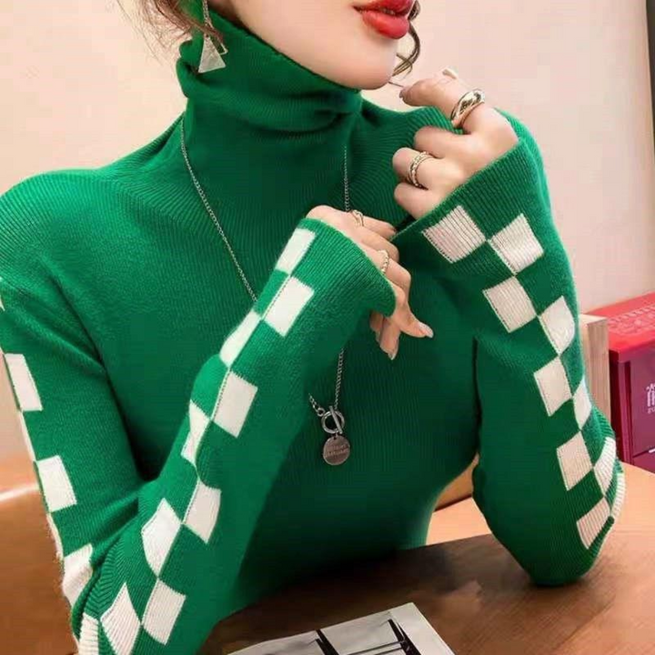 Vrouw in groene coltrui met witte ruitpatronen, draagt zilveren sieraden. Modieuze dameskleding, herfst-winter stijl, trendy outfit.