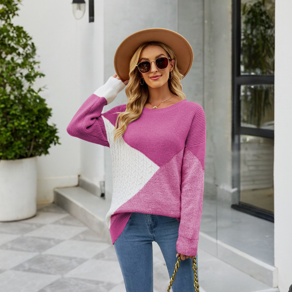 Vrouw in roze trui met geometrisch patroon, zonnebril en hoed, poseert buiten. Modieuze dameskleding, casual herfststijl.