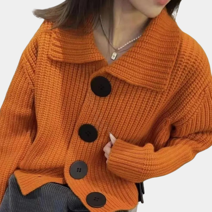 Oranje gebreid damesvest met grote zwarte knopen, brede kraag en lange mouwen. Modieuze herfstkleding, ideaal voor casual en stijlvolle outfits.