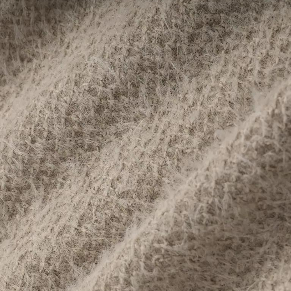 Beige wollen stoftextuur close-up, zachte en pluizige vezels, ideaal voor winterkleding en interieurdecoratie. Hoogwaardige textielmaterialen.