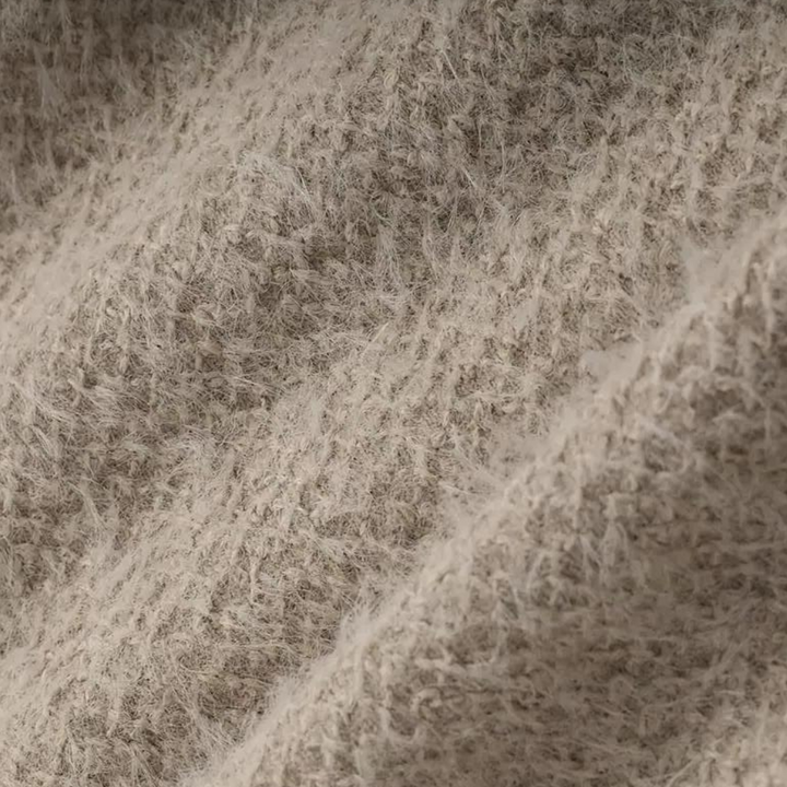 Beige wollen stoftextuur close-up, zachte en pluizige vezels, ideaal voor winterkleding en interieurdecoratie. Hoogwaardige textielmaterialen.