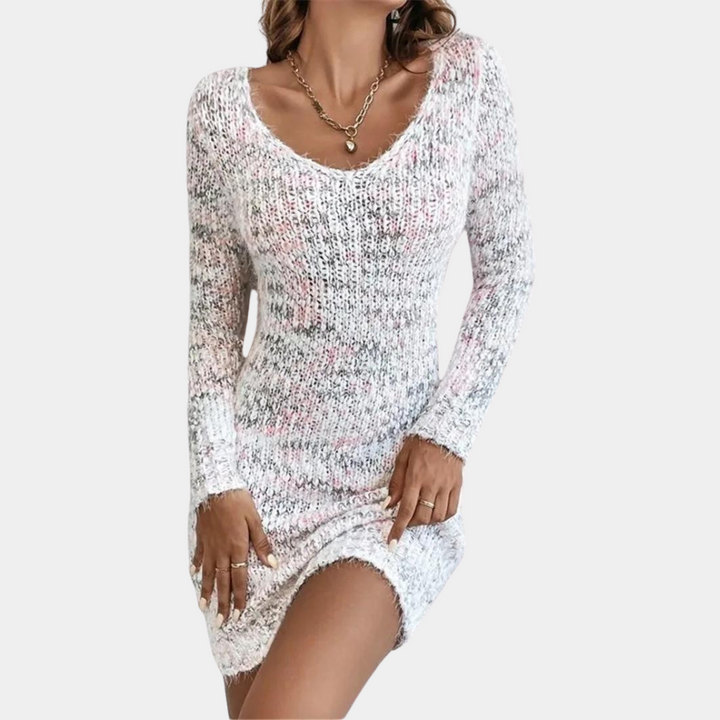 Vrouw in gebreide roze en witte jurk met lange mouwen, V-hals en sieraden. Modieuze dameskleding, trendy outfit voor casual gelegenheden.