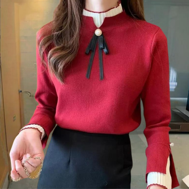 Rode damestrui met zwarte strik en pareldetail, gecombineerd met zwarte rok. Elegante herfstmode, stijlvolle kantooroutfit, trendy dameskleding.