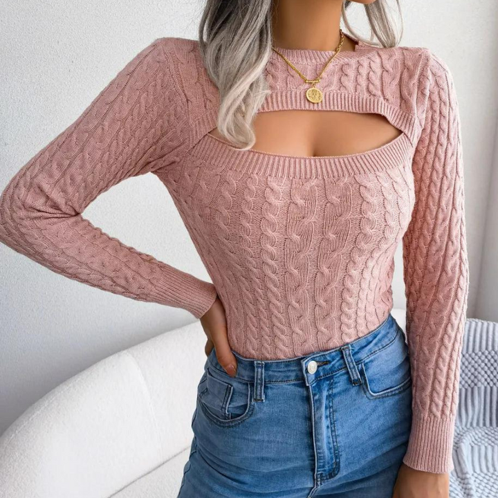 Roze gebreide trui met open schouderdetail, gedragen door model met blond haar. Perfect voor modieuze dameskleding en herfsttrends.