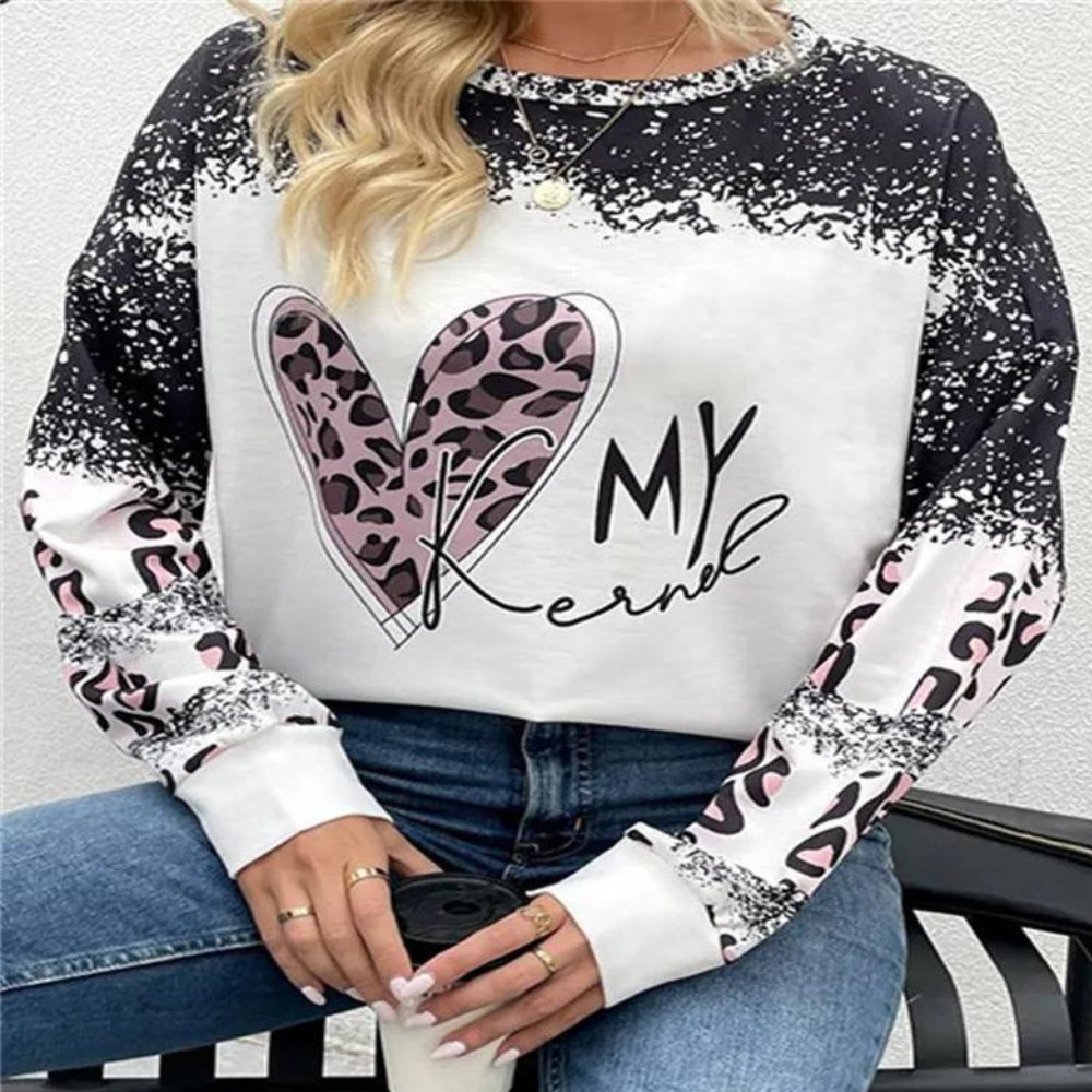 Vrouw draagt trendy trui met luipaardprint hart en tekst "K My Kernel", casual mode, zwart-wit ontwerp, populaire dameskleding.