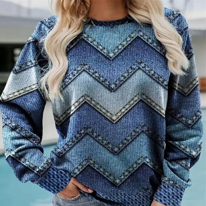 Blonde vrouw draagt blauwe trui met zigzag denim patroon, casual mode, trendy dameskleding, comfortabele herfst- en winterstijl.