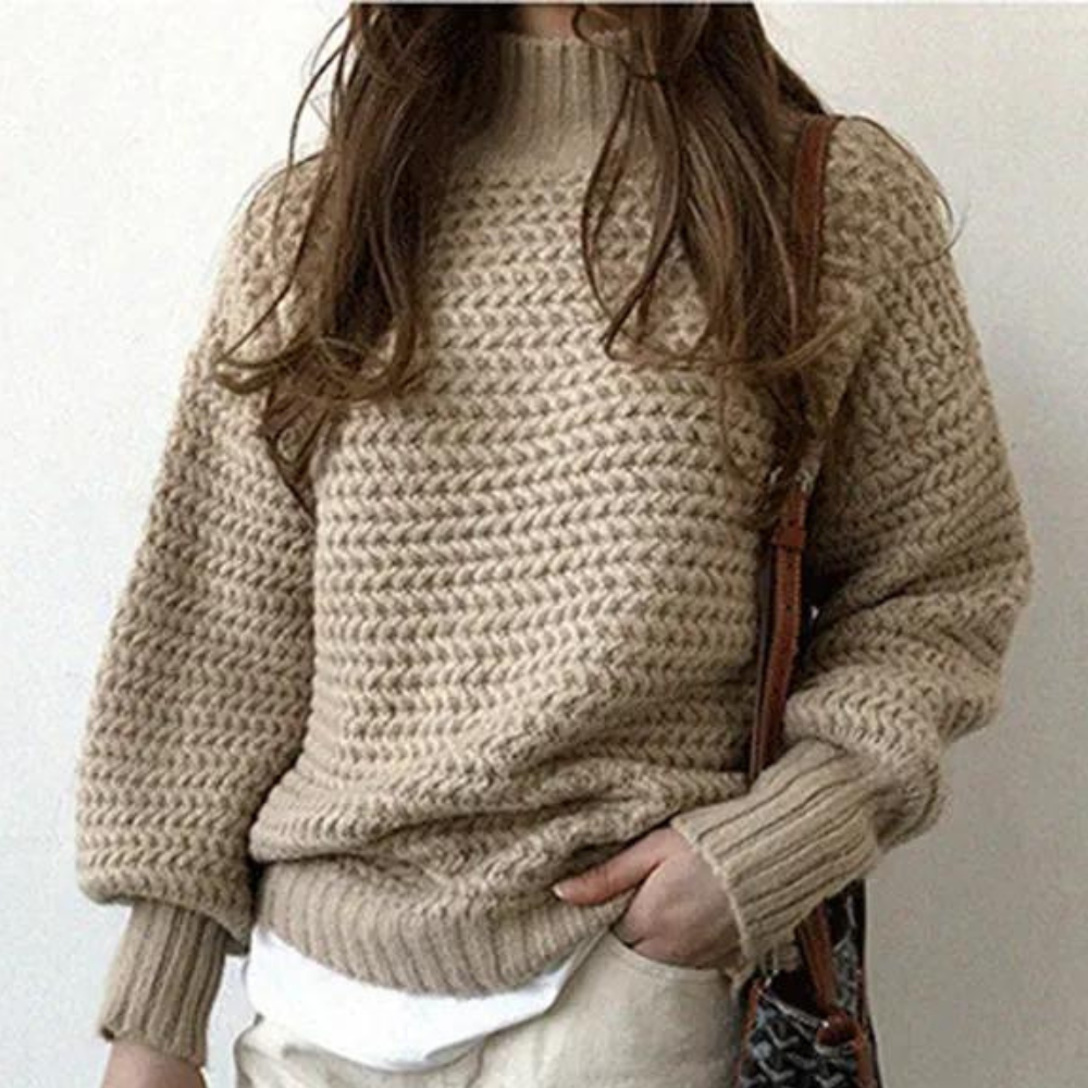 Beige gebreide trui met lange mouwen, gedragen door vrouw. Modieuze dameskleding, herfst-winter stijl, comfortabele casual outfit.