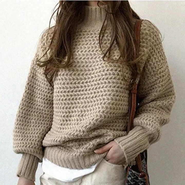 Beige gebreide trui met lange mouwen, gedragen door vrouw. Modieuze dameskleding, herfst-winter stijl, comfortabele casual outfit.