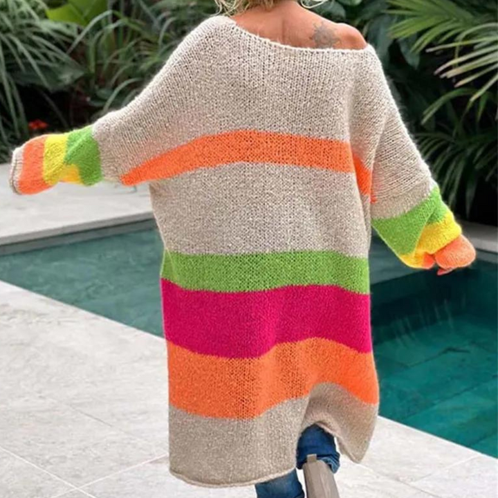 Vrouw in oversized gebreide trui met kleurrijke strepen bij zwembad, modieuze dameskleding, herfstmode, comfortabele outfit.