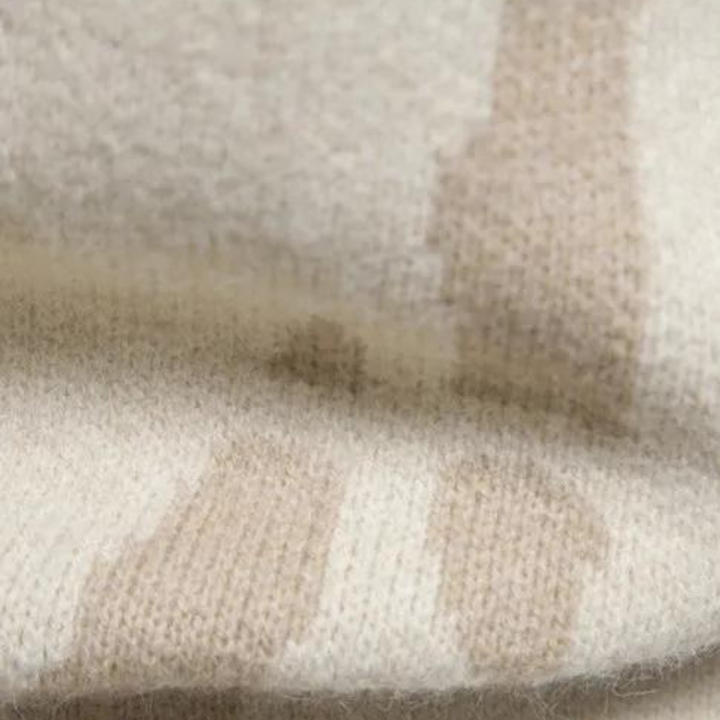 Beige wollen deken met strepen, close-up textuur. Zachte, warme plaid voor interieurdecoratie. Hoogwaardige, duurzame stof.