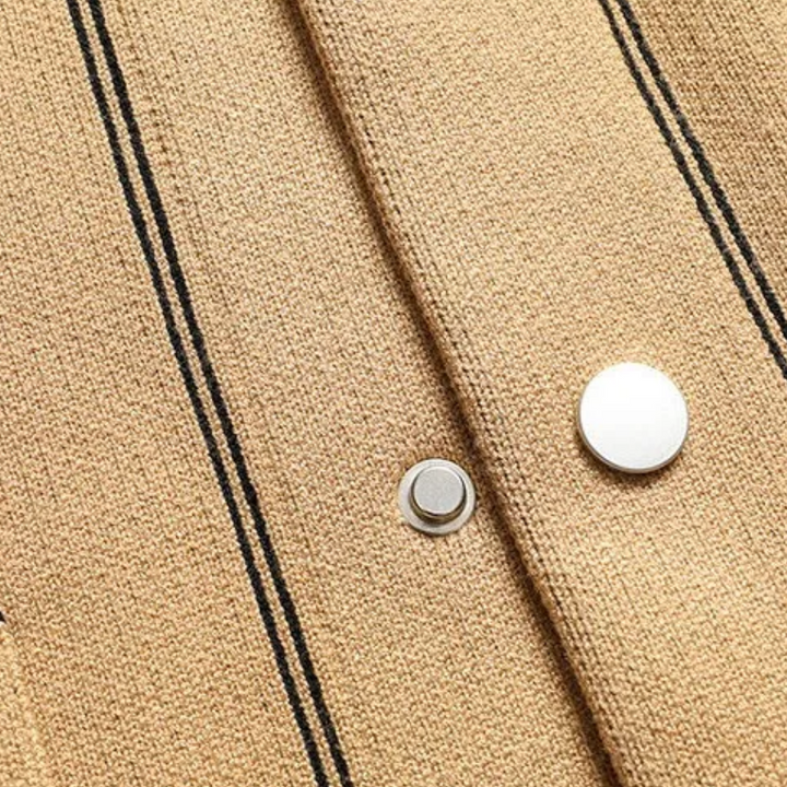 Beige wollen jas met zwarte strepen en zilveren knopen, close-up. Stijlvolle damesmode, herfstkleding, hoogwaardige materialen.