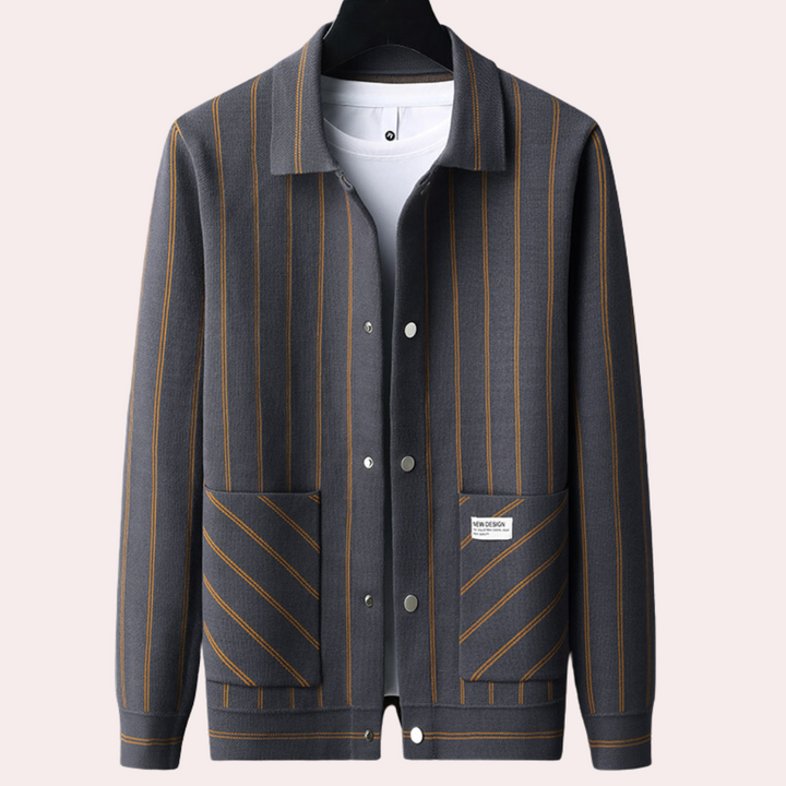 Grijze gestreepte herenjas met bruine strepen, knoopsluiting en zakken, hangend aan een hanger. Stijlvolle herenkleding, moderne jas.