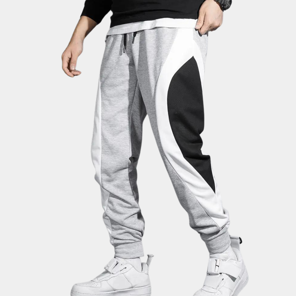 Grijze joggingbroek met zwart-witte zijpanelen, sportief design, comfortabele pasvorm, ideaal voor casual en sportieve outfits.