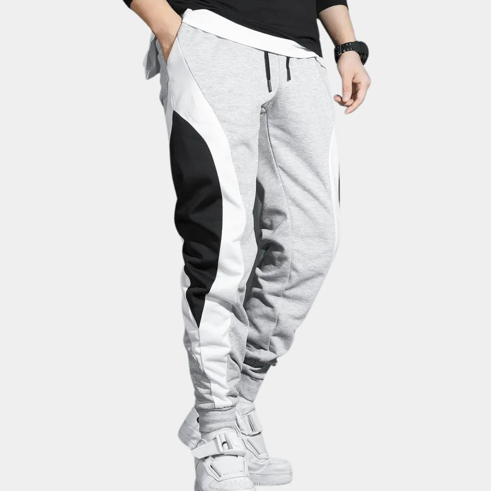 Lichtgrijze joggingbroek met zwart-witte zijstrepen, sportief design, comfortabele pasvorm, ideaal voor casual en sportieve outfits.