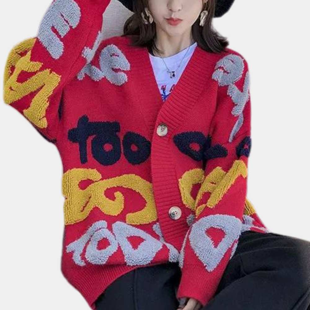 Vrouw draagt rode oversized gebreide trui met kleurrijke letters, trendy mode, herfst-winter stijl, casual streetwear, comfortabele kleding.