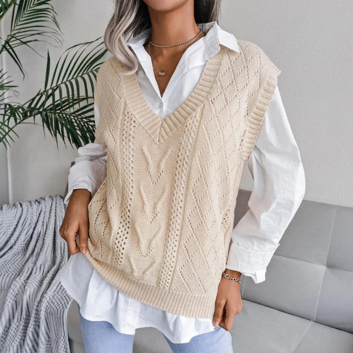 Vrouw draagt gebreide beige spencer over witte blouse, casual chique stijl, perfect voor herfstmode. Trendy dameskleding, comfortabele outfit.